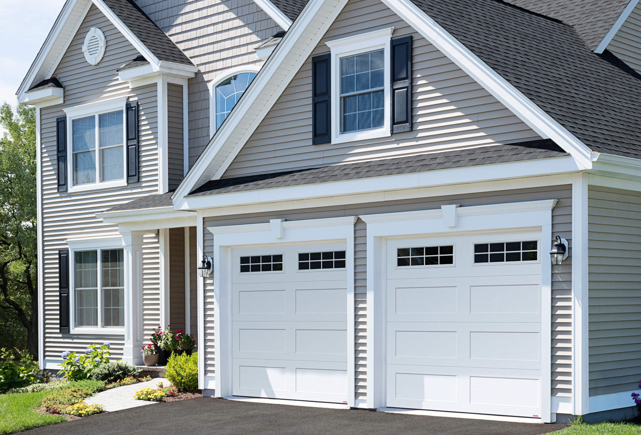 a grey house with double white garage doors