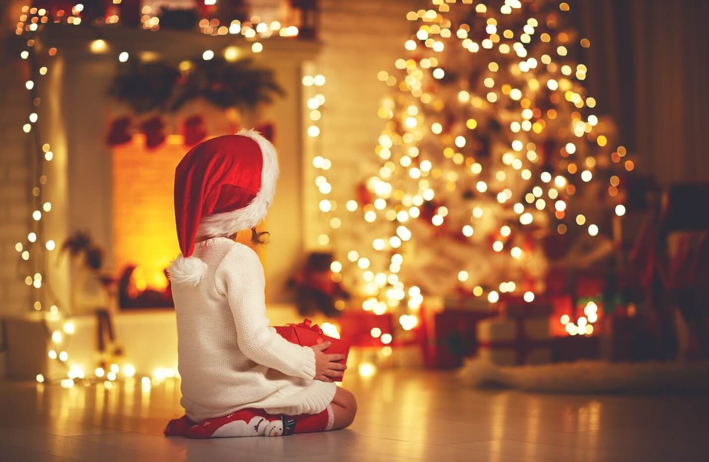 child sitting in front of a Christmas tree