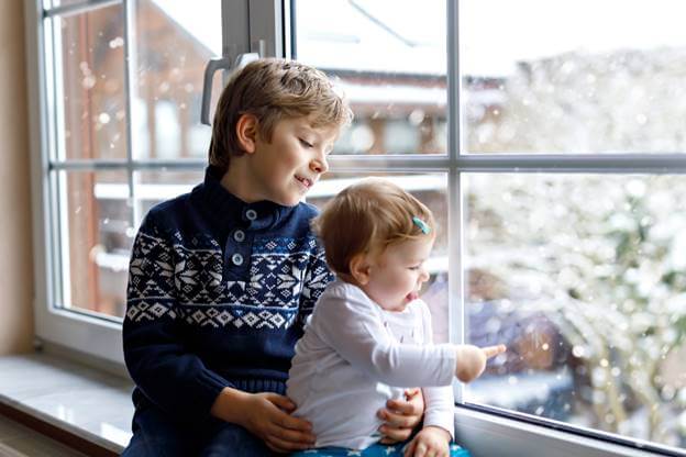 Children Looking Out Window in Winter