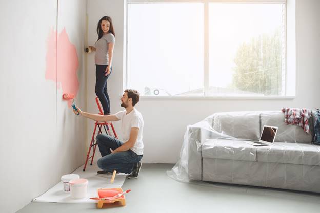 Couple Painting a Wall Near a Window