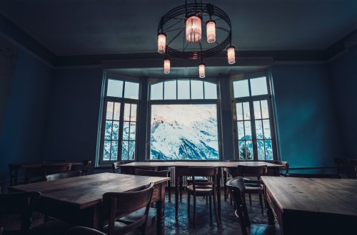 a large bay window with a dining room table and a chandelier