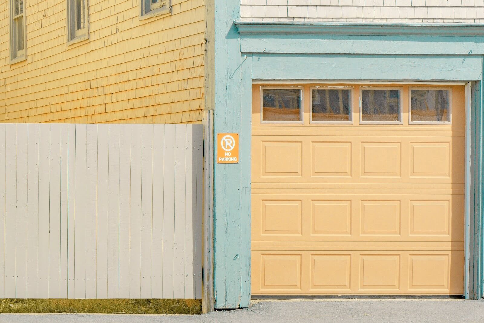 a yellow garage door with light blue stucco walls