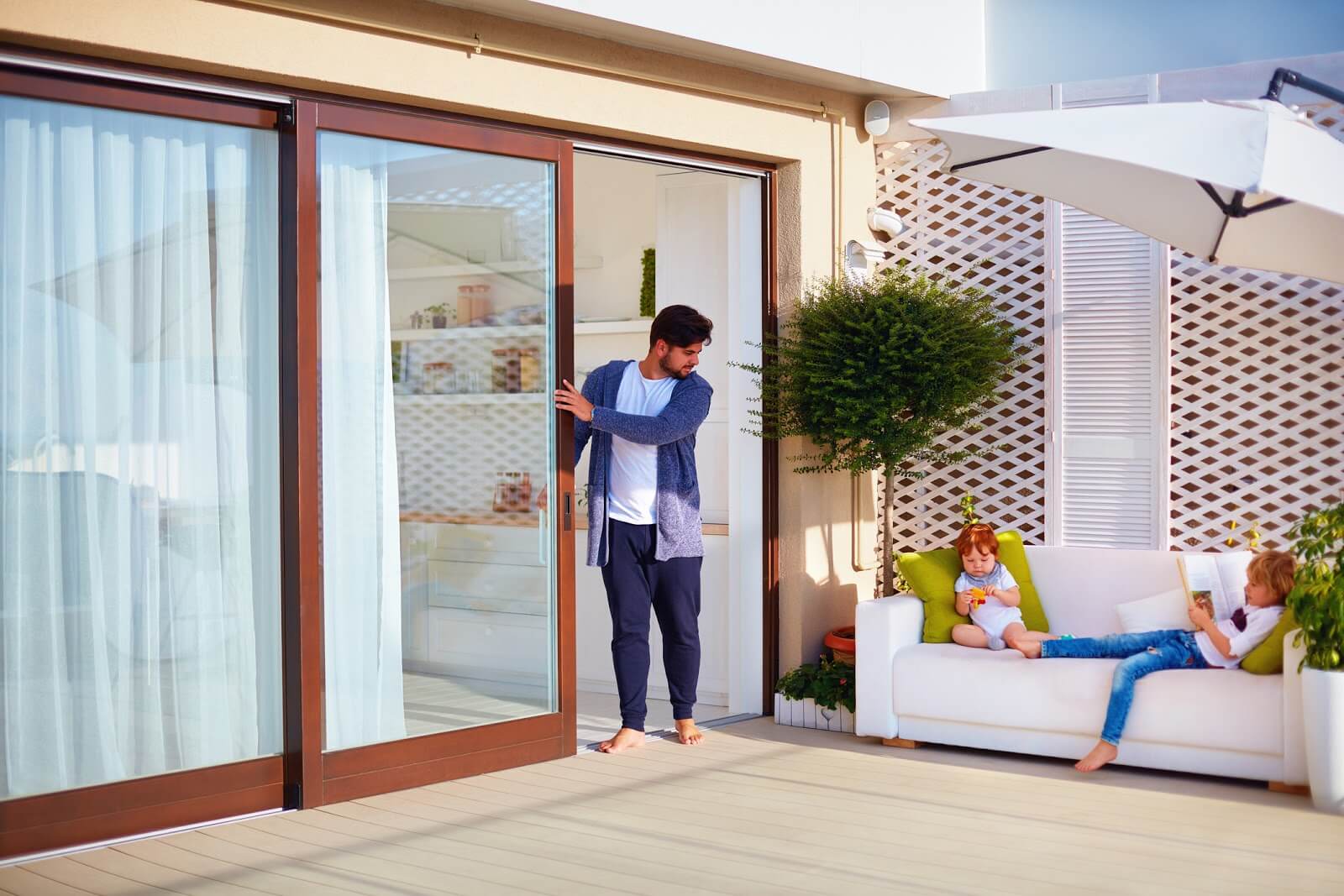 a man coming outside while pushing aside a sliding door