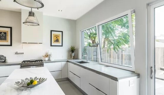 A kitchen with two white vinyl windows.