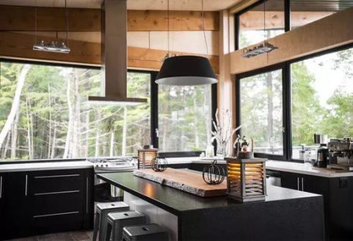 A modern kitchen with windows surrounding it.