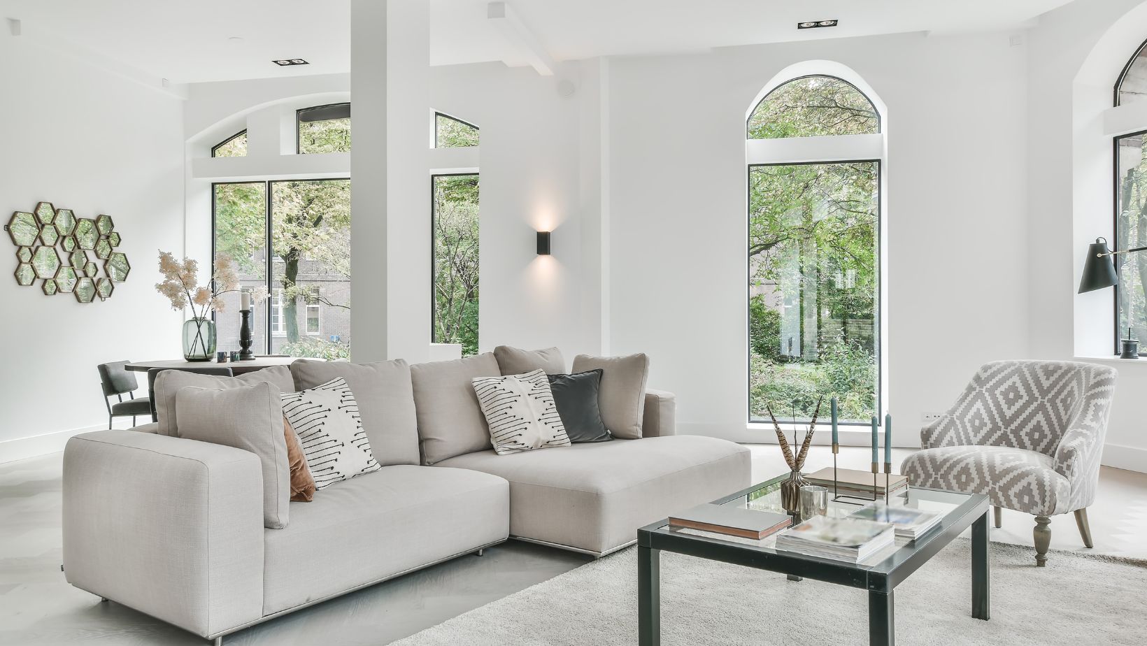 A white livingroom with a white couch and gray & white chair.