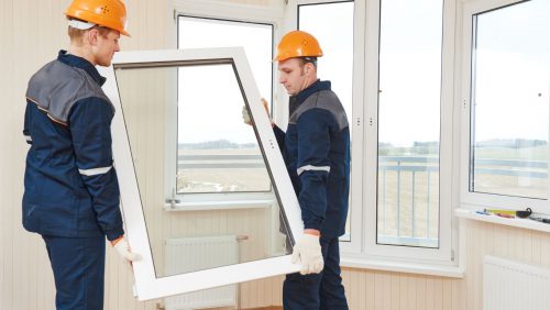 Two men installing a window.