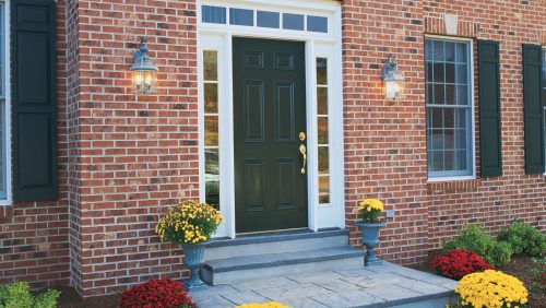A black front door surrounded by white trim and tiny windows.