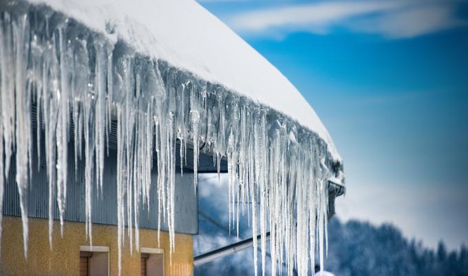 Roof with snow and icicles forming from an ice dam.