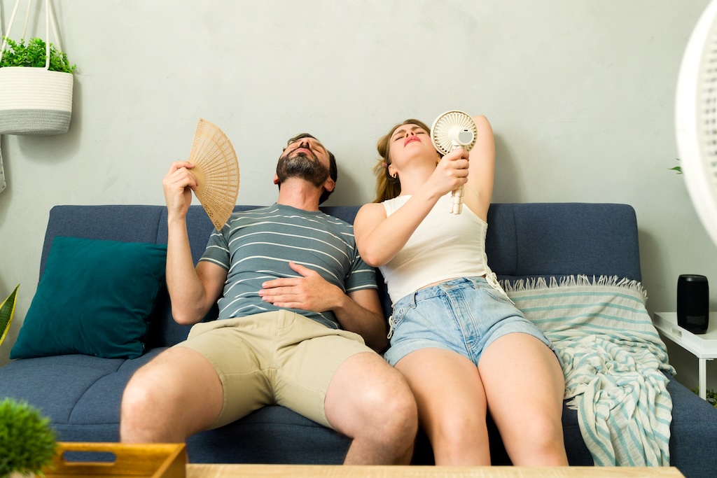 Overheated couple fanning selves